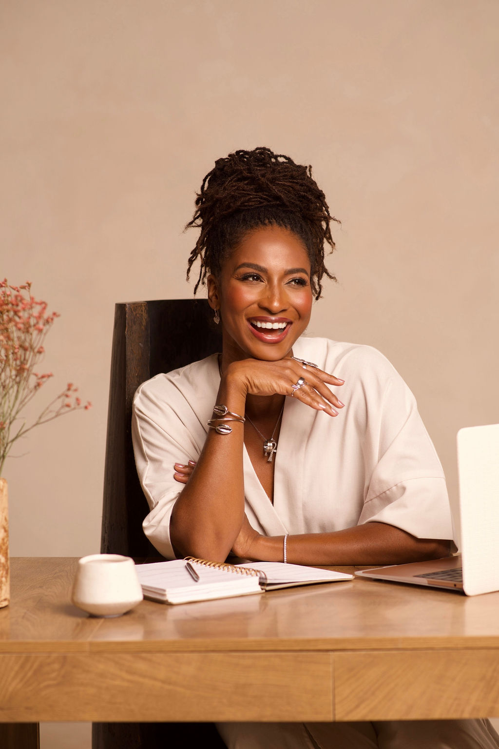 Koya Webb sitting and smiling at desk